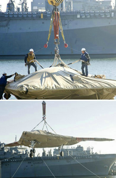 資料圖：美國(guó)海軍人員將一架X-47B無(wú)人空戰(zhàn)系統(tǒng)驗(yàn)證機(jī)運(yùn)送到杜魯門號(hào)航母上。