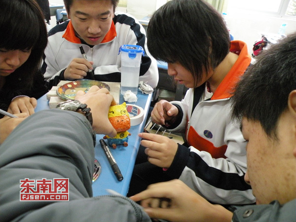 同學(xué)們?cè)诶蠋煹闹笇?dǎo)下制作心愿卡作品。