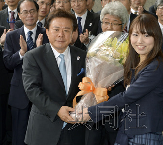 12月18日，高票當(dāng)選東京都新知事的豬瀨直樹正式到任。圖為豬瀨從政府職員手中接過花束。(共同社)