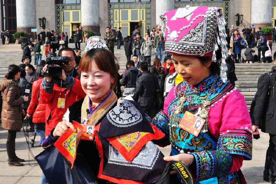 云南代表團(tuán)的兩位女代表在為記者展示她們帶來的民族特色手工藝品。 人民網(wǎng)記者 馬麗婭 攝