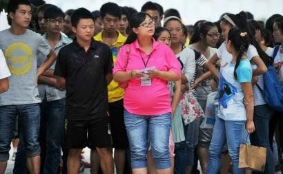 6月7日，雅安天全中學(xué)的呂莎莎老師(中)在考場外等待自己的學(xué)生出來。