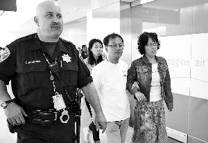 失事客機乘客在警察的保護下離開機場。
