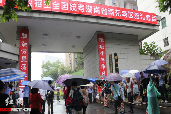 高考學(xué)子冒雨進(jìn)入考場。