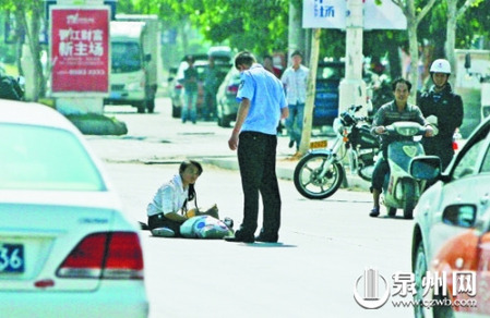 女孩從摩的上摔下，跌坐路中央，恰遇社區(qū)聯(lián)防巡邏人員扶起。