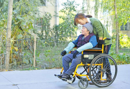 10月11日，張學琴用輪椅推著母親在校園里散步。