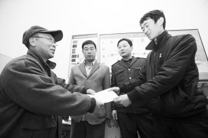 劉大爺莊重地將感謝信交到車隊隊長的手中。本報記者 李志華 攝
