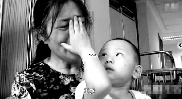 視頻中“小中寶”看到奶奶為他掉眼淚，就伸手為奶奶抹去眼淚。視頻截圖 
