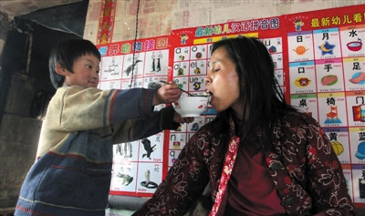 小孫悅為臥床的母親喂飯。