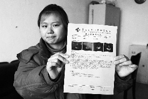 女孩眼含淚水向記者出示自己母親的診斷報(bào)告，希望好心人可以幫幫她的母親?！　z影 李自強(qiáng)