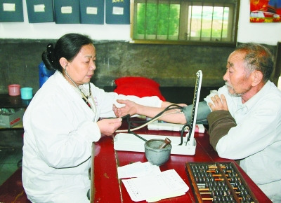 曾玉萍(左)在為患者看病。 喻無瑕 攝