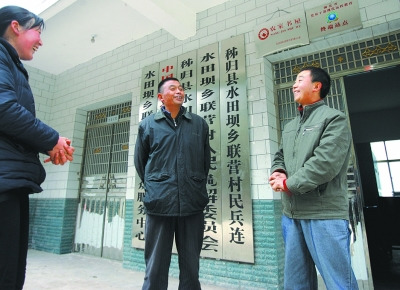  張義波(右)和村主任等村干部商談工作。
