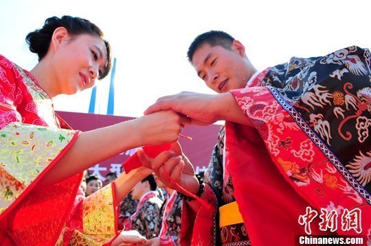 9月1日，一場別開生面的“重溫漢唐風(fēng)”漢式集體婚禮在泉城濟(jì)南舉行，72名新人身著傳統(tǒng)漢服喜結(jié)良緣，并在許愿墻上許下“千年共枕眠，一世永相愛”心愿。圖為新人解纓結(jié)發(fā)。中新社發(fā) 張勇 攝
