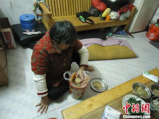 17日下午，56歲小兒麻痹癥患者張紅英爬在地板上找東西。 蘇路程 攝