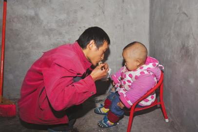 詹圓圓出門前給兒子喂飯。