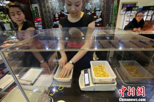金店工作人員正在稱重。　張?jiān)啤z