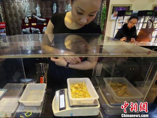 金店工作人員正在稱重。　張?jiān)啤z