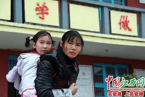 蘭愛(ài)紅背著女兒放學(xué)。