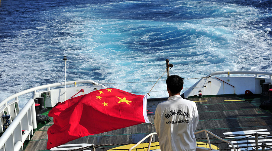 3月18日，水手李國棟在南海救101輪船甲板后部升起國旗。新華社記者 趙穎全攝