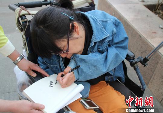 洛洛正在給買(mǎi)書(shū)的顧客簽名。 馮曉林 攝