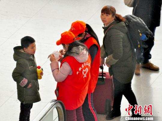 鐵路青年志愿者為攜帶兒童出行的旅客提供咨詢(xún)解答?！钦鳌z