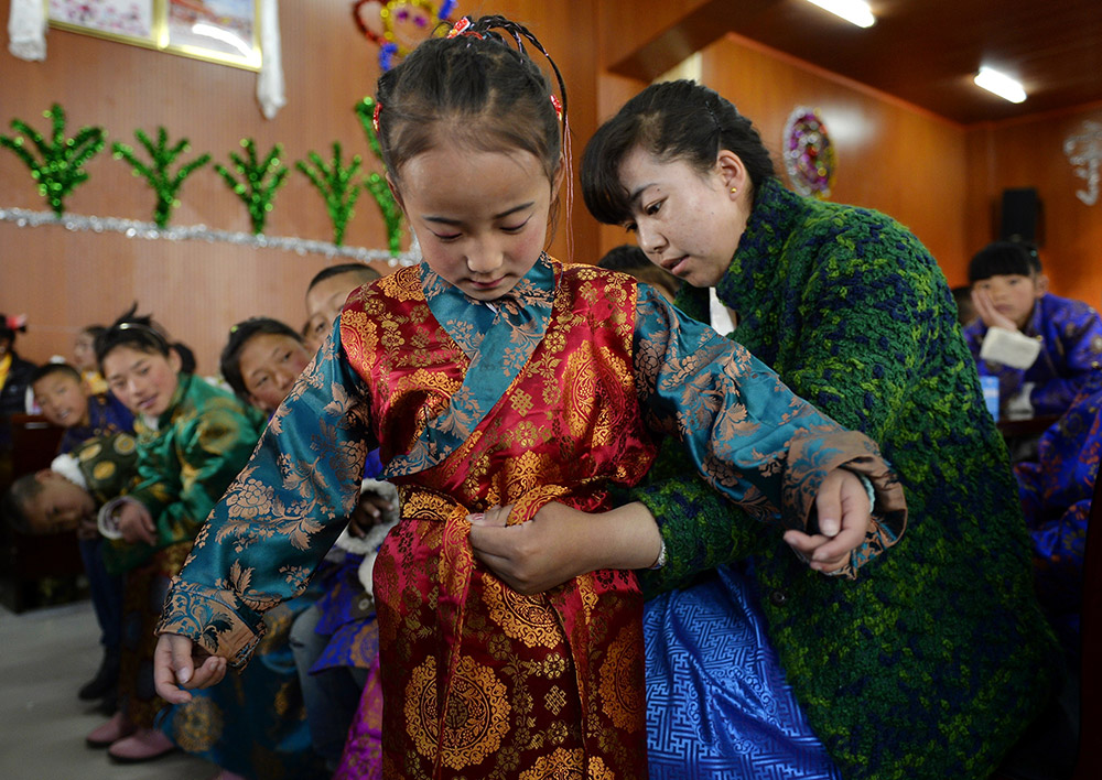 2月27日，在西藏自治區(qū)兒童福利院，來自拉薩市尼木縣的“愛心媽媽”德慶旺姆（右）在為來自那曲地區(qū)的嘎瑪曲宗換上節(jié)日盛裝。